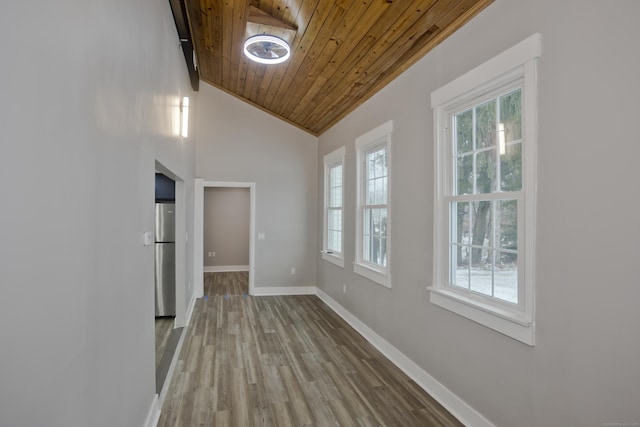 corridor with plenty of natural light, vaulted ceiling, wood-type flooring, and wooden ceiling