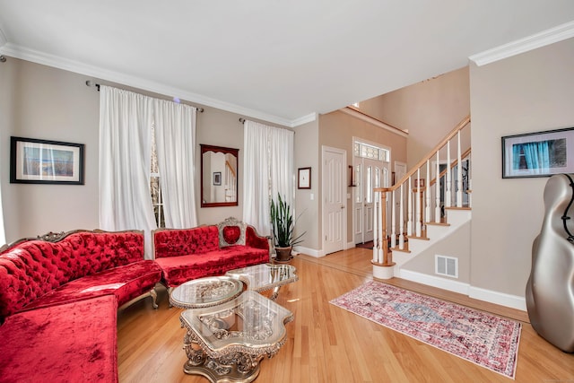 living room featuring stairs, wood finished floors, visible vents, and ornamental molding