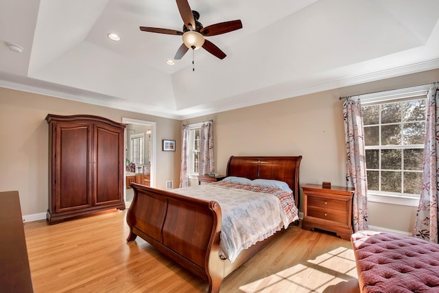 bedroom with a raised ceiling, recessed lighting, baseboards, and light wood-type flooring