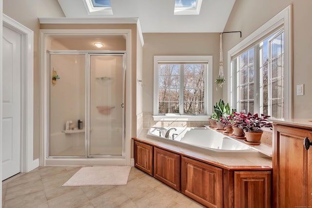 full bath with lofted ceiling with skylight, a garden tub, a stall shower, and tile patterned flooring