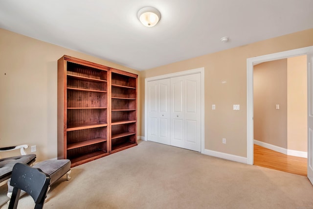 unfurnished room with baseboards and light carpet