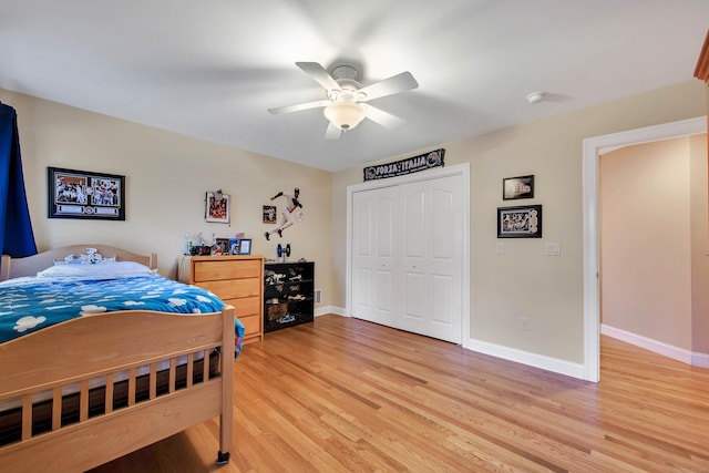 bedroom featuring light wood finished floors, a closet, baseboards, and a ceiling fan