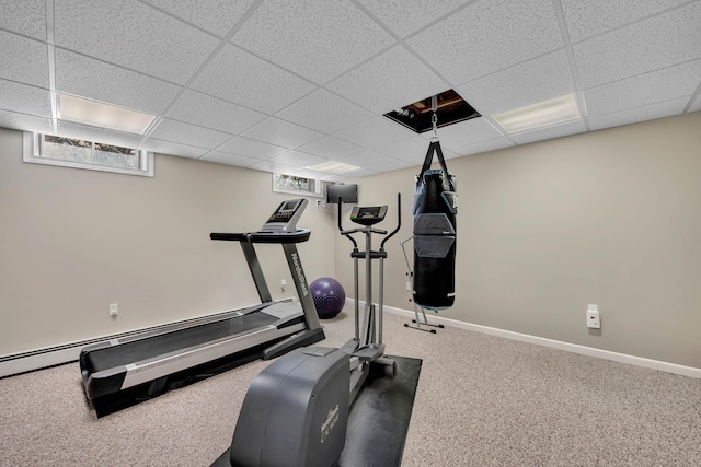 exercise area with a paneled ceiling, baseboards, and carpet