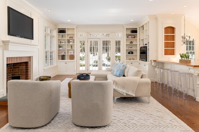 sitting room featuring crown molding, a fireplace, wood finished floors, and recessed lighting