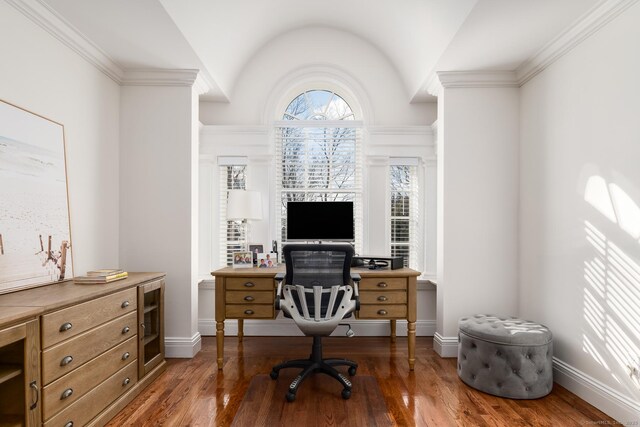 office space featuring ornamental molding, baseboards, vaulted ceiling, and hardwood / wood-style floors