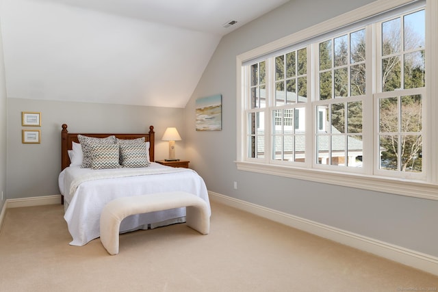 carpeted bedroom with vaulted ceiling and baseboards