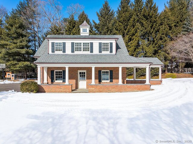 view of front of home with covered porch and brick siding