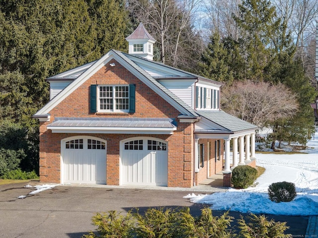 view of front of home featuring brick siding and aphalt driveway