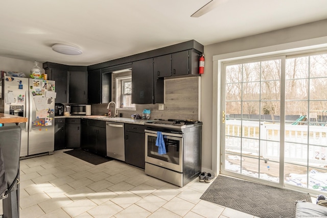 kitchen featuring appliances with stainless steel finishes, sink, and light tile patterned floors