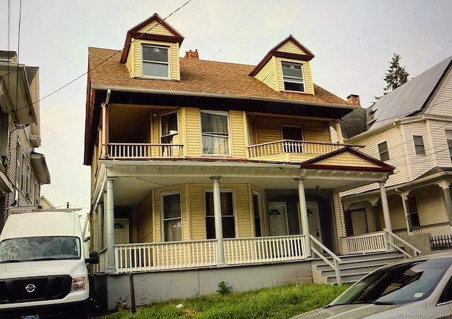 view of front of property with a porch and a balcony