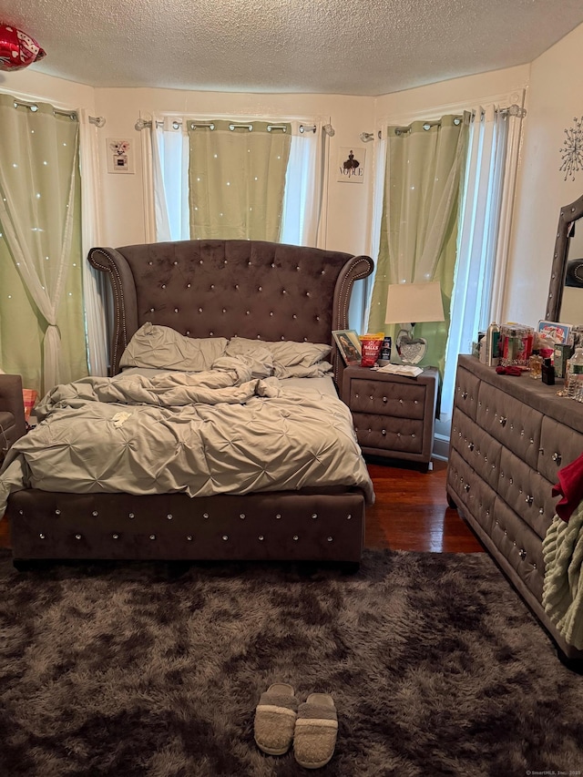 bedroom with dark wood-type flooring and a textured ceiling