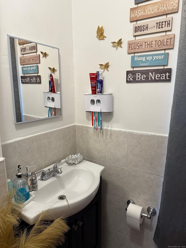 bathroom with a wainscoted wall, tile walls, and vanity