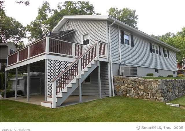 rear view of property featuring a yard, central AC, and a deck