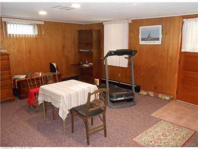 dining area featuring wooden walls and carpet