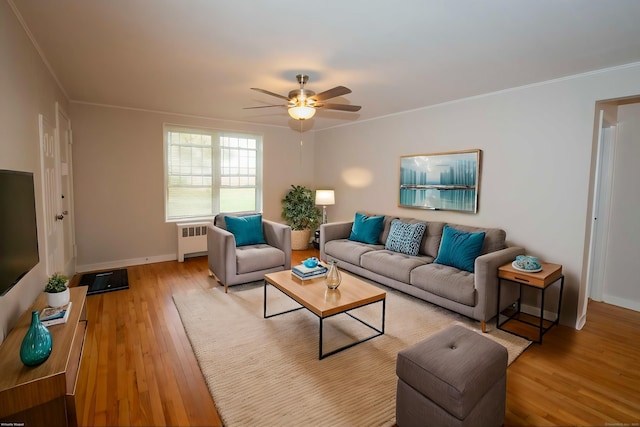 living room with radiator, ornamental molding, ceiling fan, and light wood-type flooring