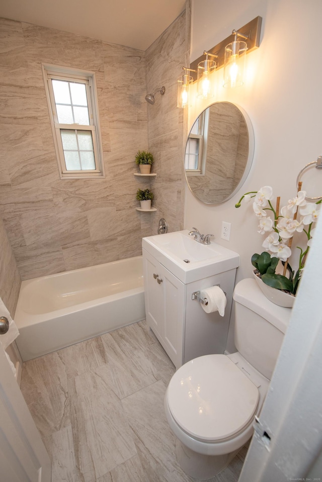 full bathroom with vanity, tiled shower / bath, and toilet