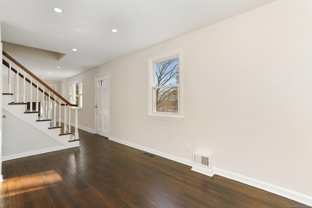 foyer entrance with a healthy amount of sunlight, hardwood / wood-style flooring, baseboards, and visible vents