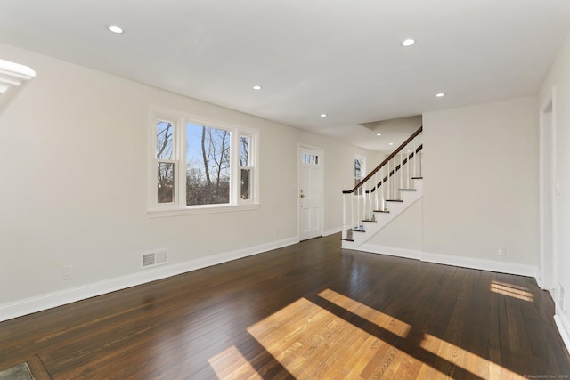 entrance foyer with baseboards, visible vents, stairway, and hardwood / wood-style floors