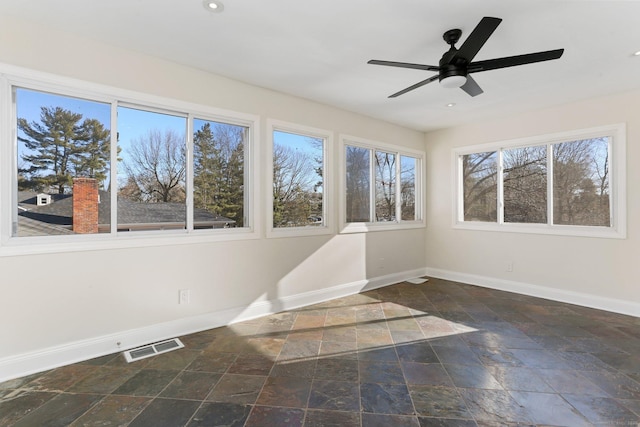 unfurnished sunroom with visible vents and a ceiling fan