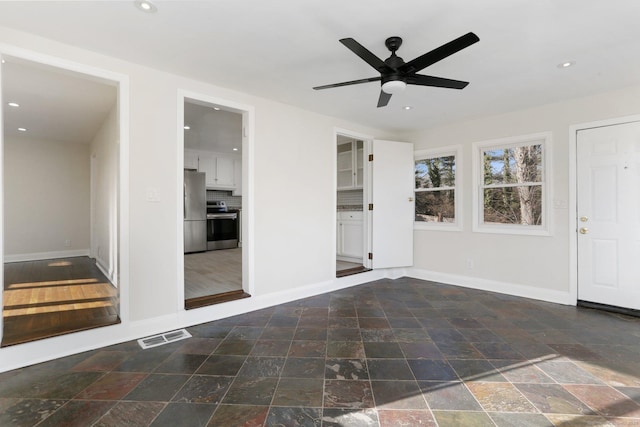 foyer with baseboards, stone finish floor, and recessed lighting