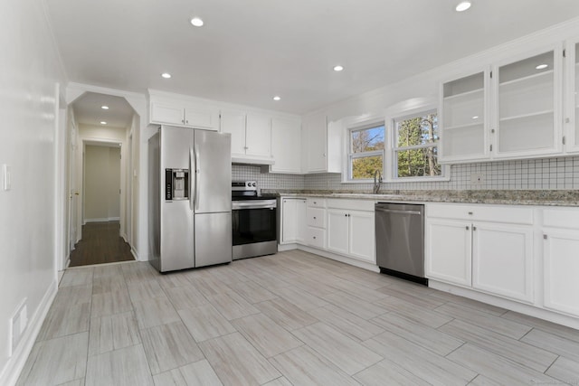 kitchen with white cabinets, tasteful backsplash, and stainless steel appliances