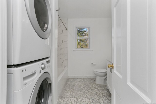 laundry area featuring stacked washer / dryer, laundry area, and baseboards