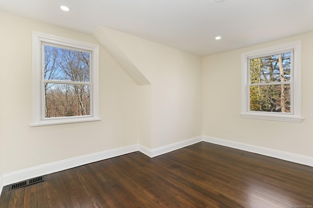 additional living space with dark wood-style flooring, recessed lighting, visible vents, and baseboards