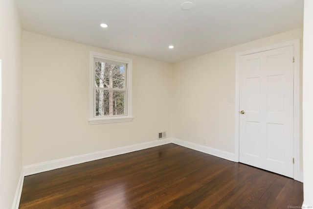 spare room featuring baseboards, visible vents, dark wood-type flooring, and recessed lighting