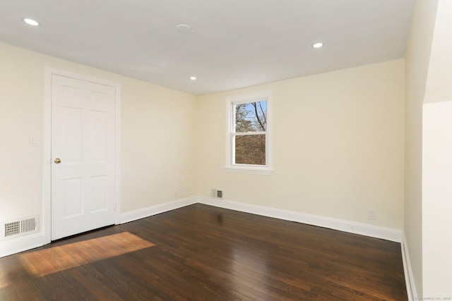 spare room featuring dark wood-style floors, recessed lighting, visible vents, and baseboards