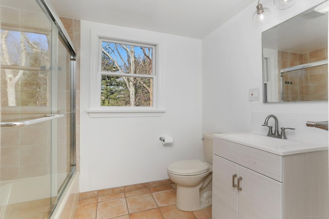 bathroom featuring shower / bath combination with glass door, tile patterned flooring, vanity, and toilet