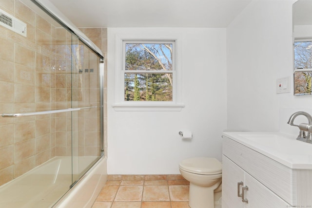 full bath with bath / shower combo with glass door, visible vents, toilet, vanity, and tile patterned floors