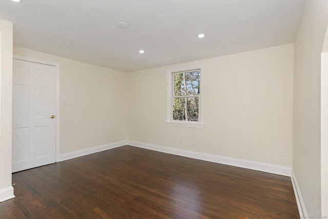 empty room with recessed lighting, dark wood finished floors, and baseboards