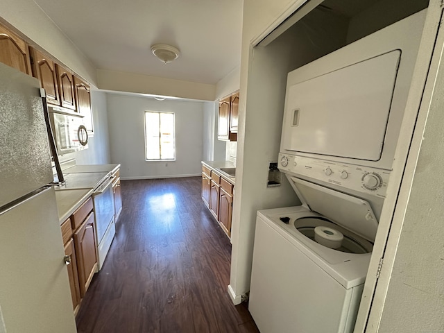 laundry room with stacked washer / drying machine and dark hardwood / wood-style floors