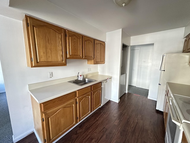 kitchen featuring white appliances, dark hardwood / wood-style flooring, and sink