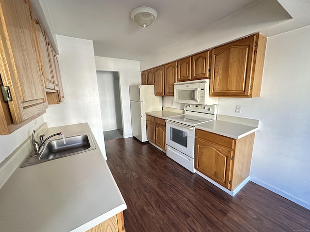 kitchen with dark wood-type flooring, white appliances, and sink