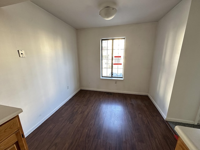 unfurnished room featuring dark wood-type flooring