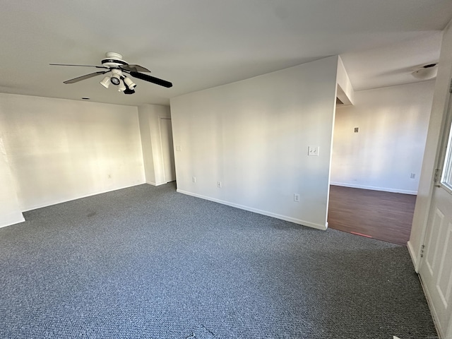 spare room featuring dark colored carpet and ceiling fan