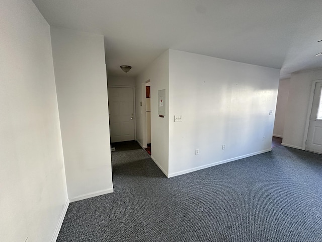 spare room with dark colored carpet