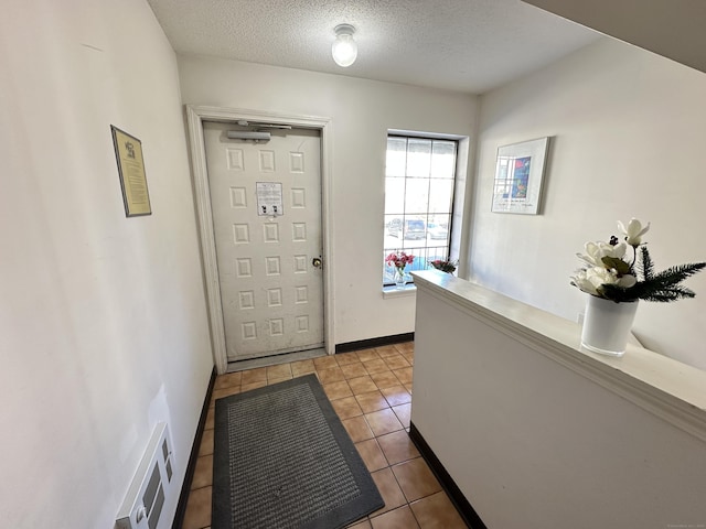 entrance foyer featuring light tile patterned floors and a textured ceiling