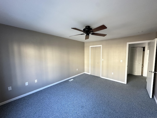 unfurnished bedroom with dark colored carpet, ceiling fan, and a closet