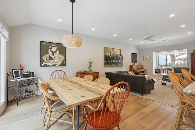 dining room with ceiling fan, lofted ceiling, and light hardwood / wood-style floors