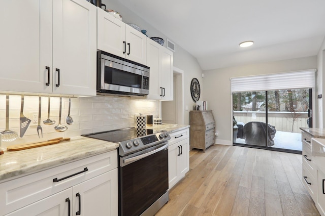 kitchen featuring light stone countertops, white cabinetry, appliances with stainless steel finishes, and decorative backsplash