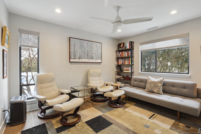 living room featuring ceiling fan and light hardwood / wood-style floors