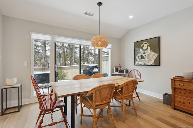 dining room with lofted ceiling and light hardwood / wood-style flooring