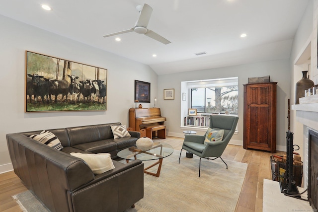 living room featuring ceiling fan, vaulted ceiling, and light wood-type flooring