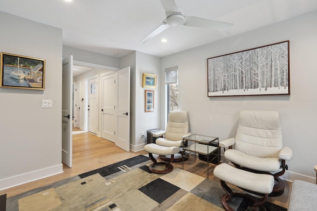 living area with hardwood / wood-style floors and ceiling fan