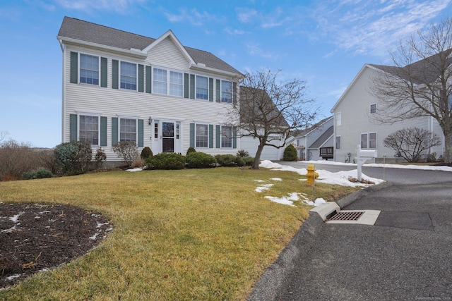 colonial-style house featuring a front lawn