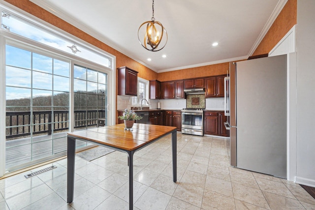 kitchen featuring stainless steel appliances, crown molding, pendant lighting, and a notable chandelier