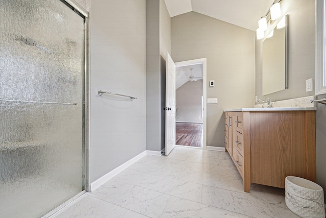 bathroom featuring vanity, a shower with shower door, and lofted ceiling