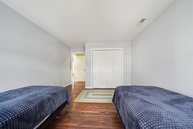 bedroom with dark hardwood / wood-style flooring and a closet